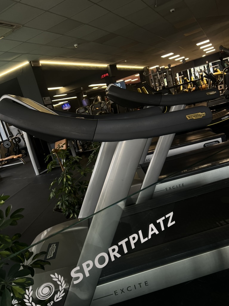 Interno della palestra Sportplatz con tapis roulant e identità visiva in primo piano
